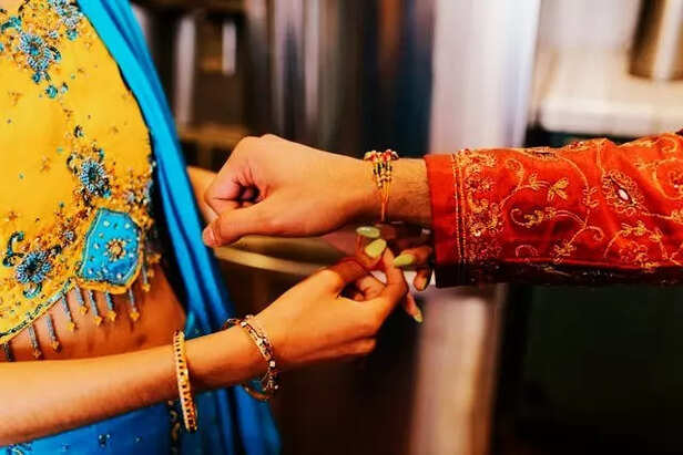 A sister tying Rakhi to b